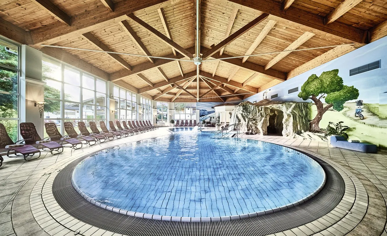 Hallenbad des Lisi Family Hotels mit Holzdecke, Liegen und Fensterfront