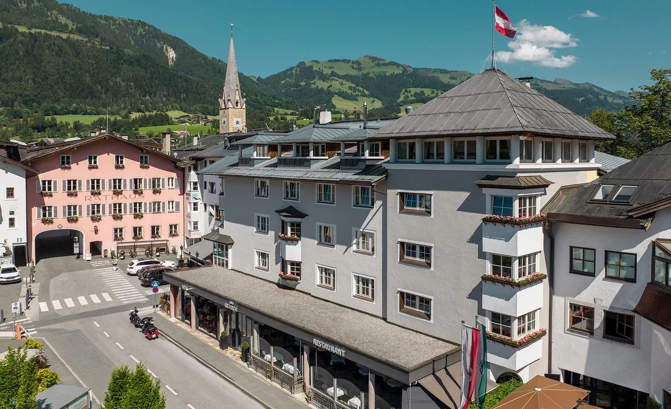 Das Reisch im Zentrum von Kitzbühel neben dem Rathaus, dahinter Kirchturm und Berge