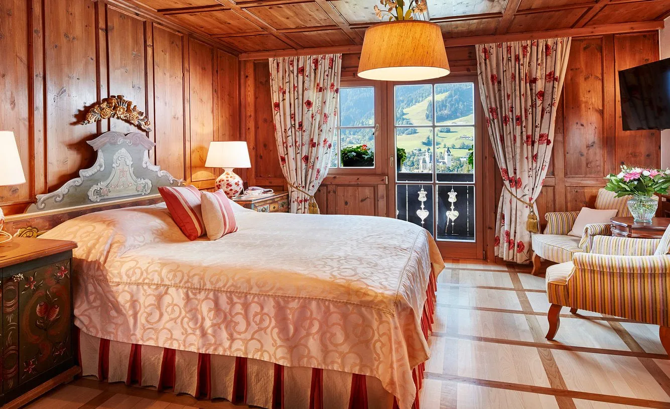 Holzvertäfeltes Zimmer im Hotel Tennerhof mit Doppelbett und Bergblick