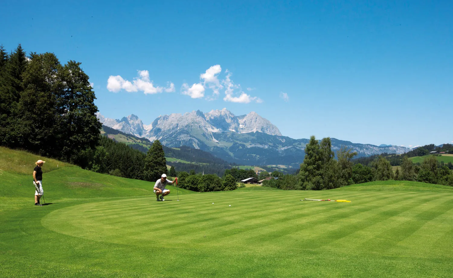 Zwei Golfer auf dem Grün, im Hintergrund der Wilde Kaiser